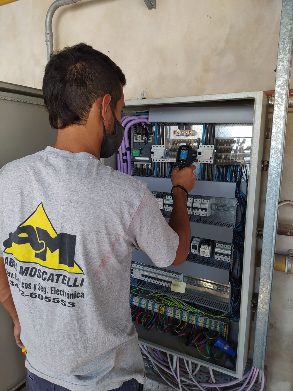 Técnico de AM SEySE inspeccionando un tablero eléctrico con cámara termográfica