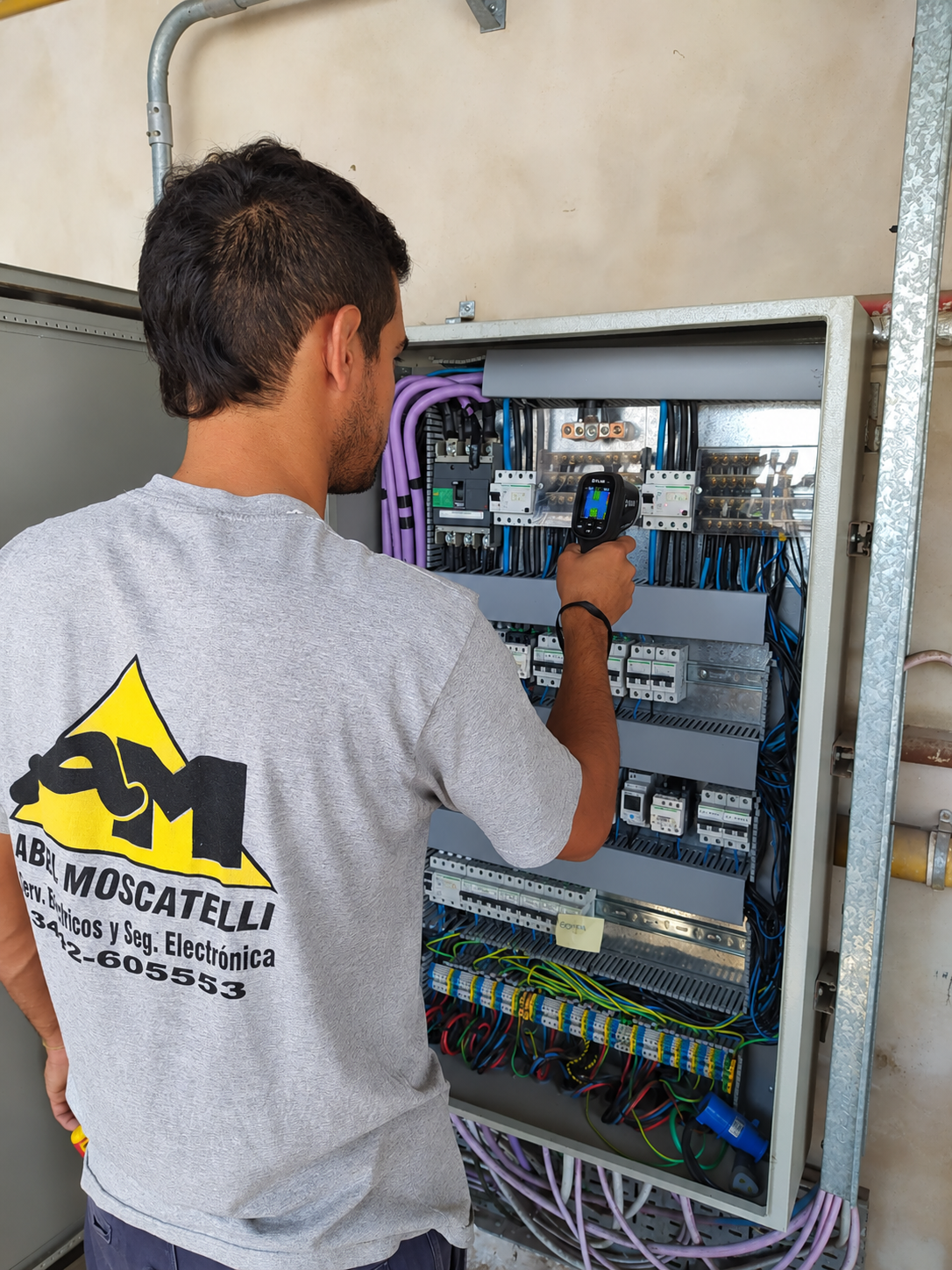 Técnico de AM SEySE inspeccionando un tablero eléctrico con cámara termográfica